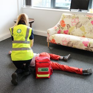 first aider tending to patient with first aid backpack
